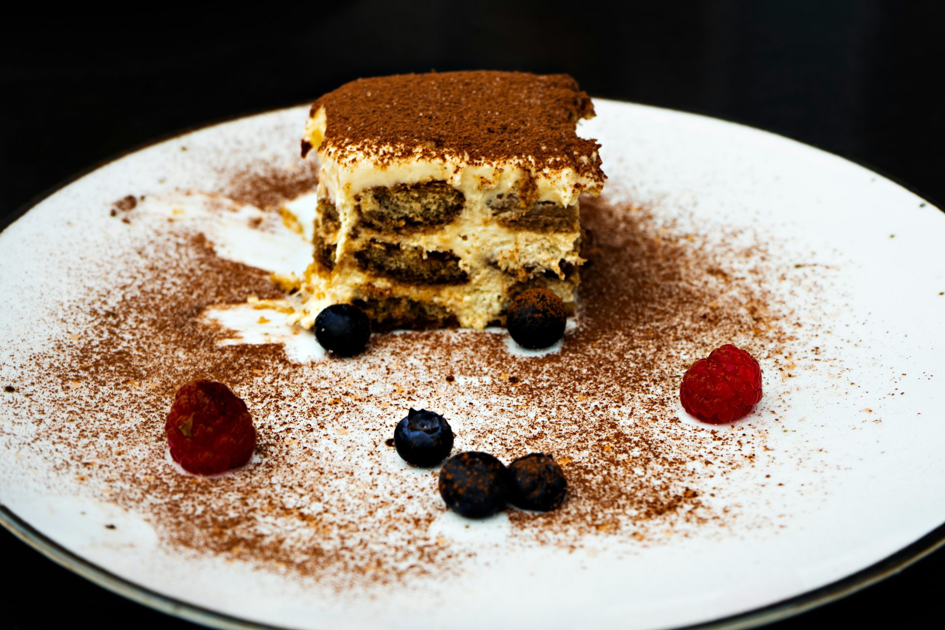 a piece of cake on a plate with berries